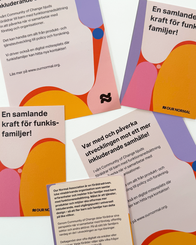 Färgglada flyers och vykort med information om Our Normal ligger på ett bord.